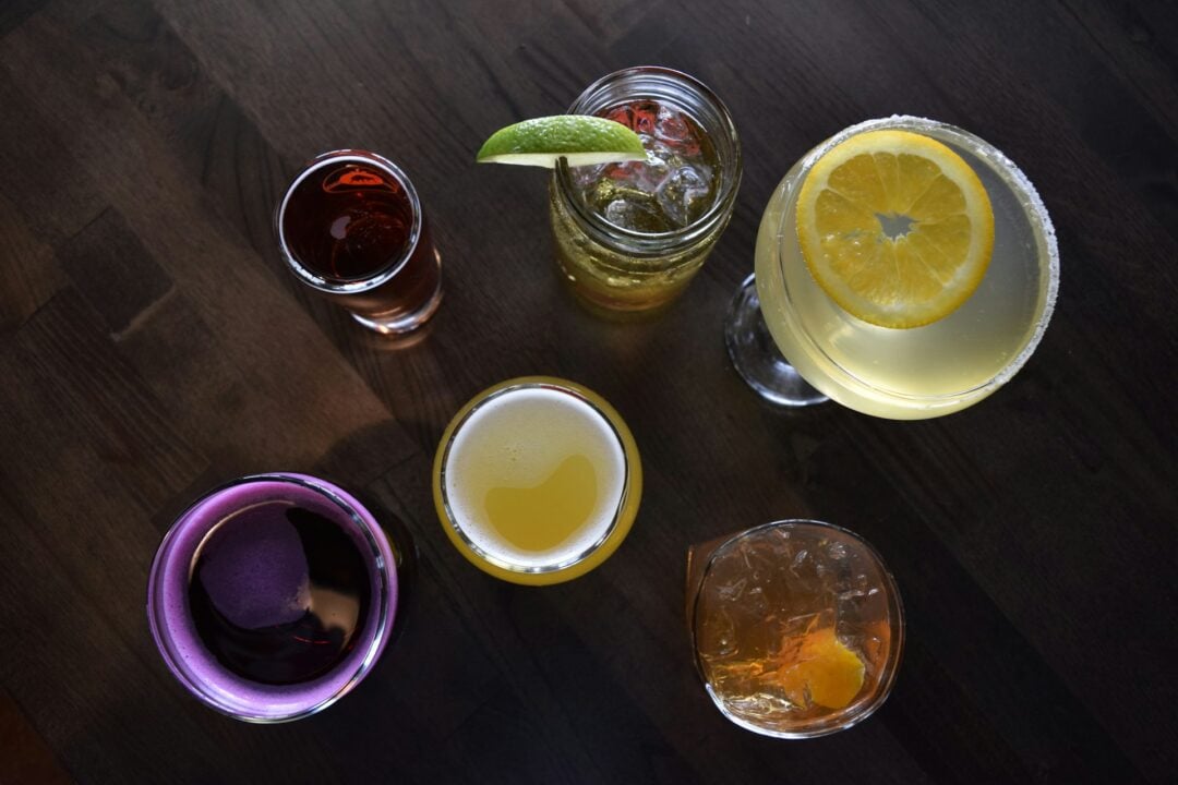a group of glasses filled with various drinks